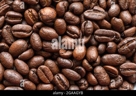 Coffee beans background. Background of roasted coffee beans. A macro photo of fried brown coffee beans on the table. Stock Photo