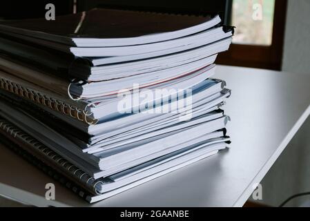 Stack of reports lies on a desk ready for review Stock Photo