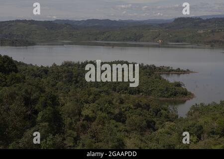 Landscape of Kampar River with hills and forest on its banks is photographed near Bangkinang in Kampar regency, Riau, Indonesia. Stock Photo