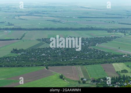 The village is densely overgrown with trees among agricultural fields. Top view Stock Photo