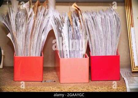 Old documents and business papers in boxes on a shelf in the archive. Selective focus Stock Photo
