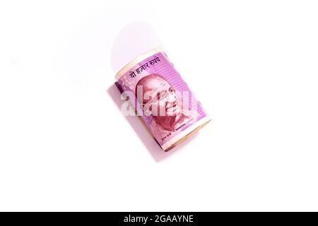 Mahatma Gandhi portrait in Indian two thousand rupees rolled up banknote isolated on white background. Stock Photo