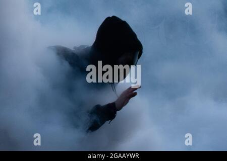 Medellin, Colombia. 28th July, 2021. A demonstrator tries to scape a tear gas cloud as demonstrations ended in late-night clashes between Colombia's riot police (ESMAD) and Demonstrators as Colombia marks 3 months of Anti-Government Protests against Colombia's president Ivan Duque government, and a new tax-reform amidst unrest and violence that left at least 83 dead since protests started. On July 28, 2021 in Medellin - Antioquia, Colombia. Credit: Long Visual Press/Alamy Live News Stock Photo