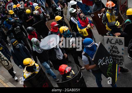 Medellin, Colombia. 28th July, 2021. Demonstrators of the front line using construction helmets and crafted shields as demonstrations ended in late-night clashes between Colombia's riot police (ESMAD) and Demonstrators as Colombia marks 3 months of Anti-Government Protests against Colombia's president Ivan Duque government, and a new tax-reform amidst unrest and violence that left at least 83 dead since protests started. On July 28, 2021 in Medellin - Antioquia, Colombia. Credit: Long Visual Press/Alamy Live News Stock Photo