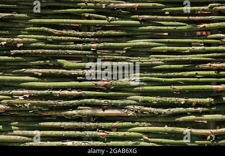 The texture of a fence woven from branches, vines, twigs and sticks. Natural old fences from improvised means. Modern landscaping and decor Stock Photo