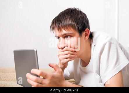 Surprised Young Man with Tablet Computer at the Home Stock Photo