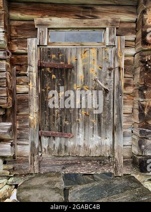 Weatherd worn wooden plank door of an old log house cabin Stock Photo