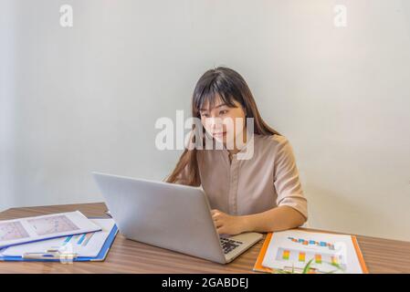 Asian businesswoman working on laptop at home Stock Photo