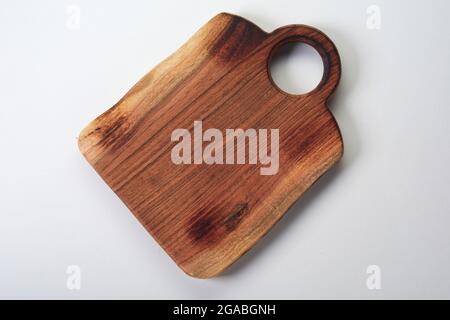 Top view of rectangular wooden chopping board with round shaped handle on white background Stock Photo