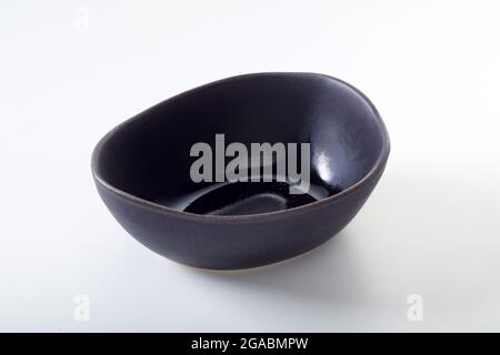 From above of empty oval shaped black ceramic bowl for food products on white background Stock Photo