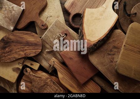 Top view full frame background with handmade rustic style natural wooden serving chopping boards of different colors and shapes Stock Photo