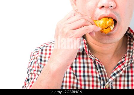 Man eating roasted chicken wings on white background Stock Photo