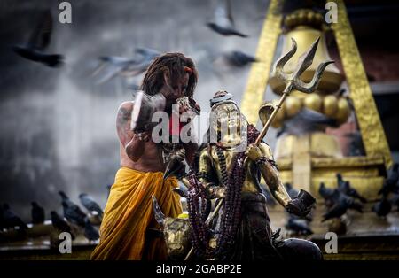 A Hindu priest blows a conch on Hanuman Jayanti, a day that