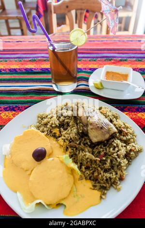 Meal in peruvian restaurant. Rice with a chicken. Potatoes with a sauce. Aji de Gallina. Stock Photo