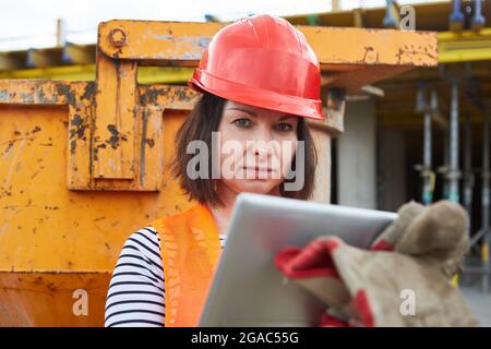 Woman as an architect or craftsman with hard hat and tablet computer on the construction site Stock Photo