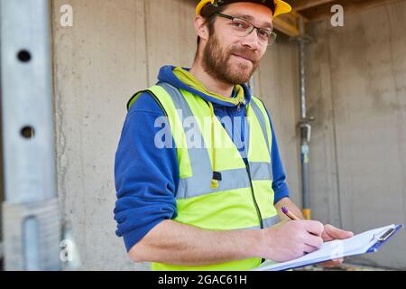 Craftsman or foreman with a checklist on clipboard makes a cost estimate Stock Photo
