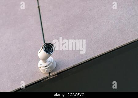 White CCTV camera on the wall with copy space Stock Photo