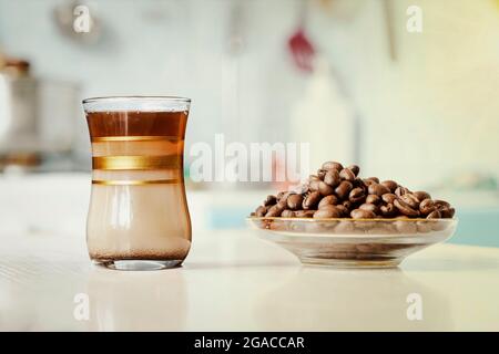 Cup of coffee with coffee beans on the background of the kitchen Stock Photo