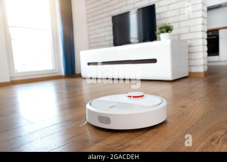 Robotic vacuum cleaner cleaning the room. Smart home concept Stock Photo