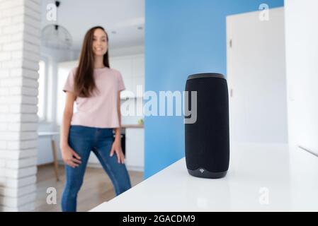 Intelligent assistant, woman talking to smart speaker device. Smart home concept Stock Photo