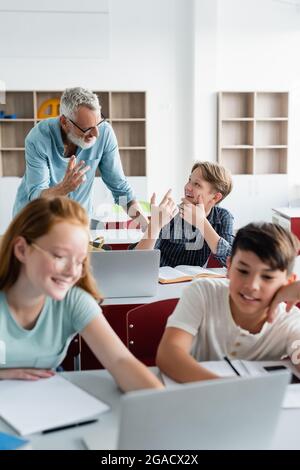 cheerful teen girl with man teacher in classroom. education Stock Photo ...