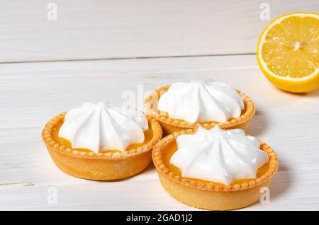 Lemon Meringue Pie. Small Lemon Meringue Pie Dessert Shortcrust Pastry with Lemon Custard Filling and Fluffy Meringue Topping Isolated on a white back Stock Photo