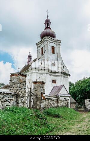 Puste Zibridovice,Czech Republic - July 12,2021. White old baroque Church of Saint Mary Magdalene with bell tower and cemetery in small Czech village Stock Photo