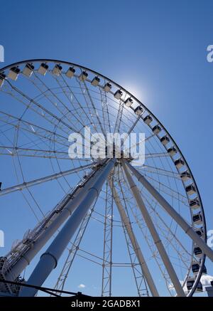 Looking up at the Grande Roue big wheel in the Montreal Old Port (Vieux Port) with the sun shining behind Stock Photo