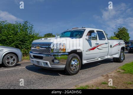 2011 modern white Chevrolet GMC 6600cc Diesel 3500 HD, 4x4 en-route to Capesthorne Hall classic July car show, Cheshire, UK Stock Photo