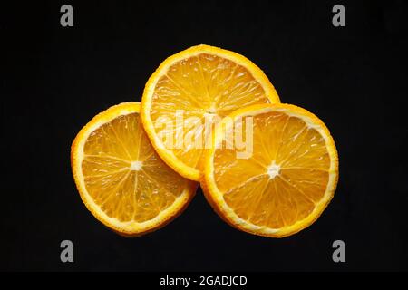 Slices of fresh orange on black background Stock Photo