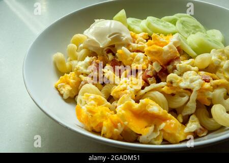 Scrambled eggs with bacon and mayonnaise in a white plate Stock Photo