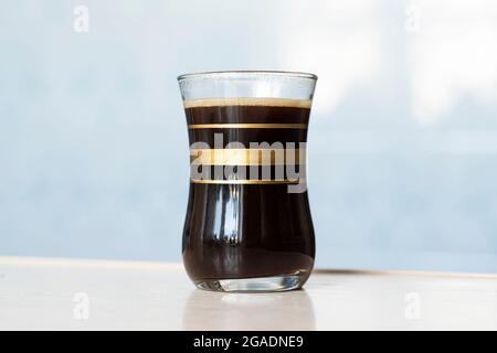 black coffee in glass cup on blue background Stock Photo