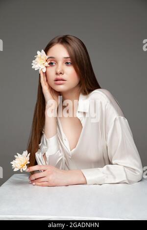Young woman covering eye with fresh flower Stock Photo