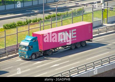 ONE Ocean Network Express shipping containers travel by truck with long trailer platform on the highway in the city. Russia. Saint-Petersburg. 18 june Stock Photo