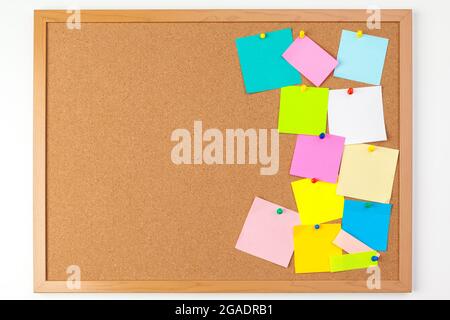 Cork board with several colorful blank notes with pins Stock Photo