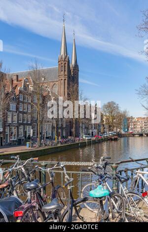 Bicycles on Heiligewegsluis (Brug 2), Singel, with De Krijtberg Kerk in background, Amsterdam, the Netherlands Stock Photo