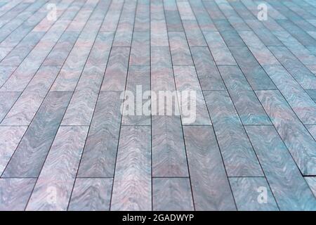 The surface with elongated rectangular stone tiles goes into perspective Stock Photo