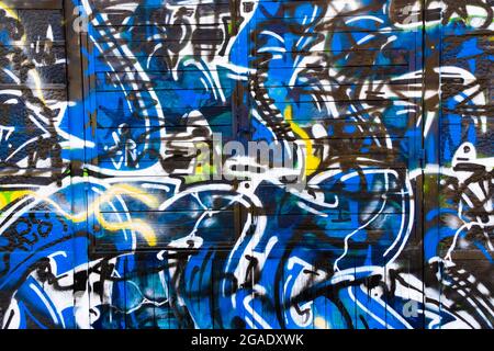 Abstract graffiti colored with blue, black white and yellow. Stock Photo