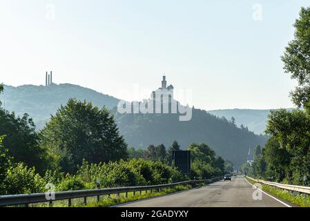Castle on top of a hill on a foggy morning, road and cars visible. Stock Photo
