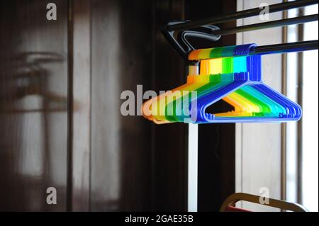 Dazzling, vibrant colours of empty plastic coat-hangers on a rack Stock Photo