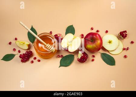 Traditional Jewish holiday New Year. Happy Rosh Hashanah. Apples, pomegranates and honey on a yellow background. Place for your text. Stock Photo