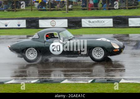 Jaguar E Type racing car competing in the RAC Tourist Trophy Celebration endurance race at the Goodwood Revival 2013 in wet conditions. Raining Stock Photo