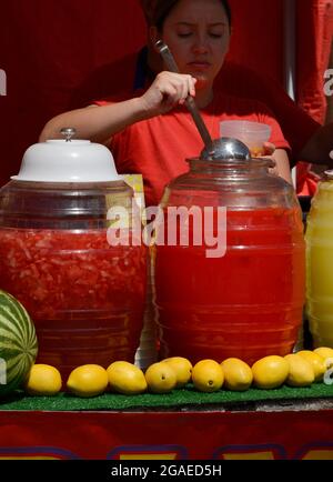 A young woman dispenses fresh squeezed juices at a festival food stand in Santea Fe, Newe Mexico. Stock Photo