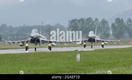 Zeltweg, Austria SEPTEMBER, 6, 2019 Two fighter jets on the air base runway under heavy rain and bad weather. Eurofighter Typhoon of Austrian air Force Stock Photo