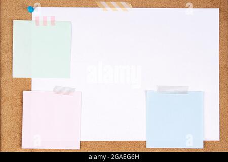 Blank white paper page and note sticks attached with adhesive tape on cork board background Stock Photo