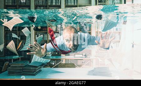 businessman swimming in a flooded office Stock Photo