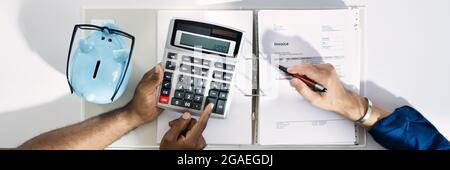 Couple Doing Taxes And Income Planning With Calculator Stock Photo