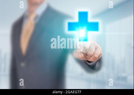Businessman hand pressing medicine sign. man press glowing medical cross sign in virtual screen. Businessman pressing cross shape icon over light blue Stock Photo