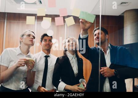 Business office team people molded on glass sticky note stickers. Stock Photo