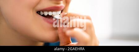 Woman Using Nicotine Gum To Quit Smoking. Nicotine Replacement Therapy Stock Photo